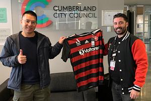 Two men holding a signed football jersey